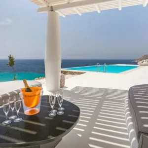 Salle à manger extérieure ombragée avec vue sur la piscine et la mer de la villa Oleandri